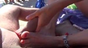 Paja con los pies de una madura en medio de la playa